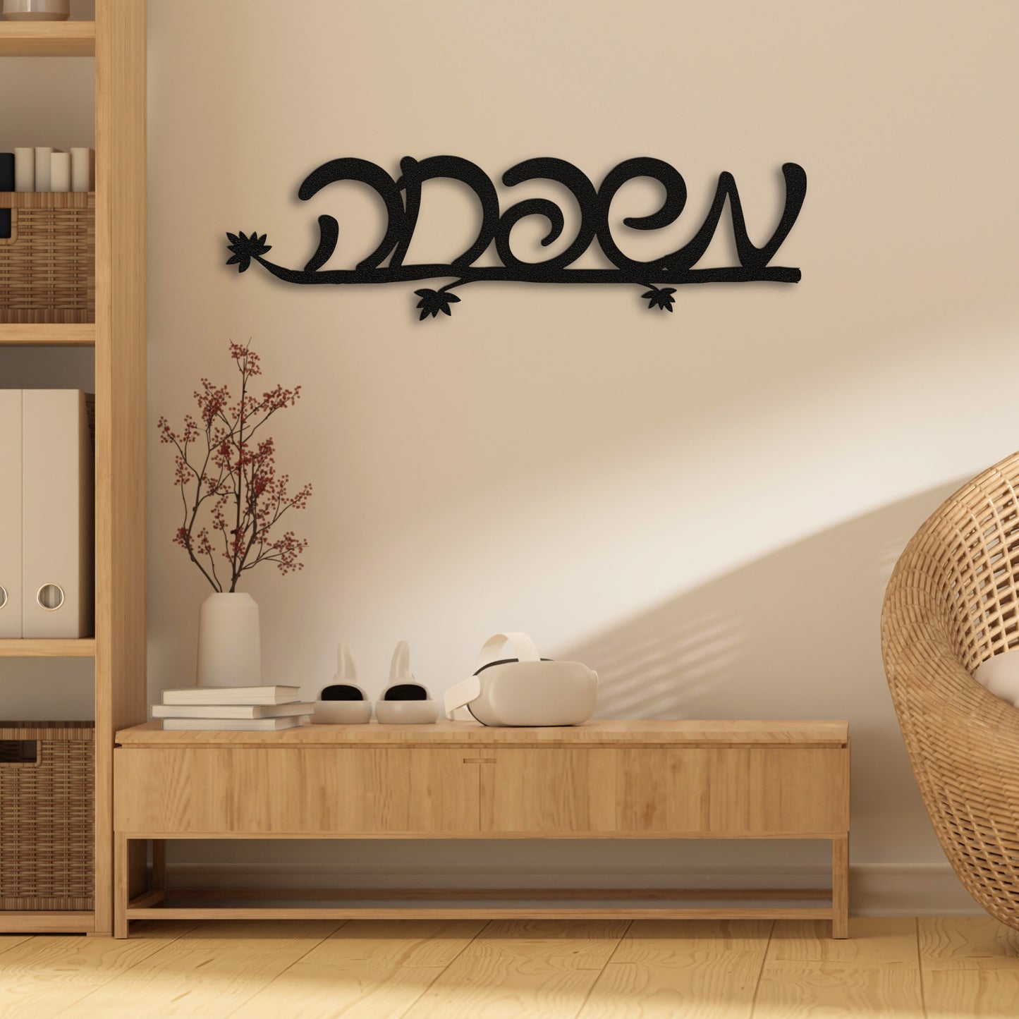 Black metal wall art with the Hebrew word 'משפחה' (Family) hanging on a beige wall above a light wood console.