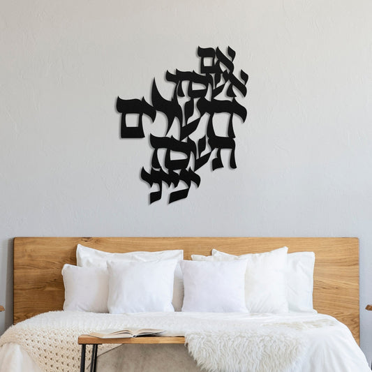 אם אשכך ירושלים" metal wall art displayed above a bed with a wooden headboard and white bedding. The black metal art is in Hebrew text, adding a modern yet cultural touch to the bedroom decor.