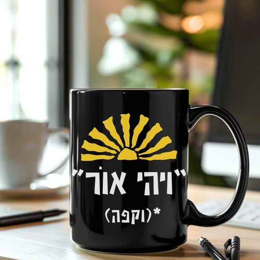 A black ceramic mug featuring the biblical quote "ויהי אור" (Let There Be Light) with the humorous addition "וקפה" (and coffee) and a sun illustration, sitting on a desk with a blurred background of a coffee cup and a notepad.