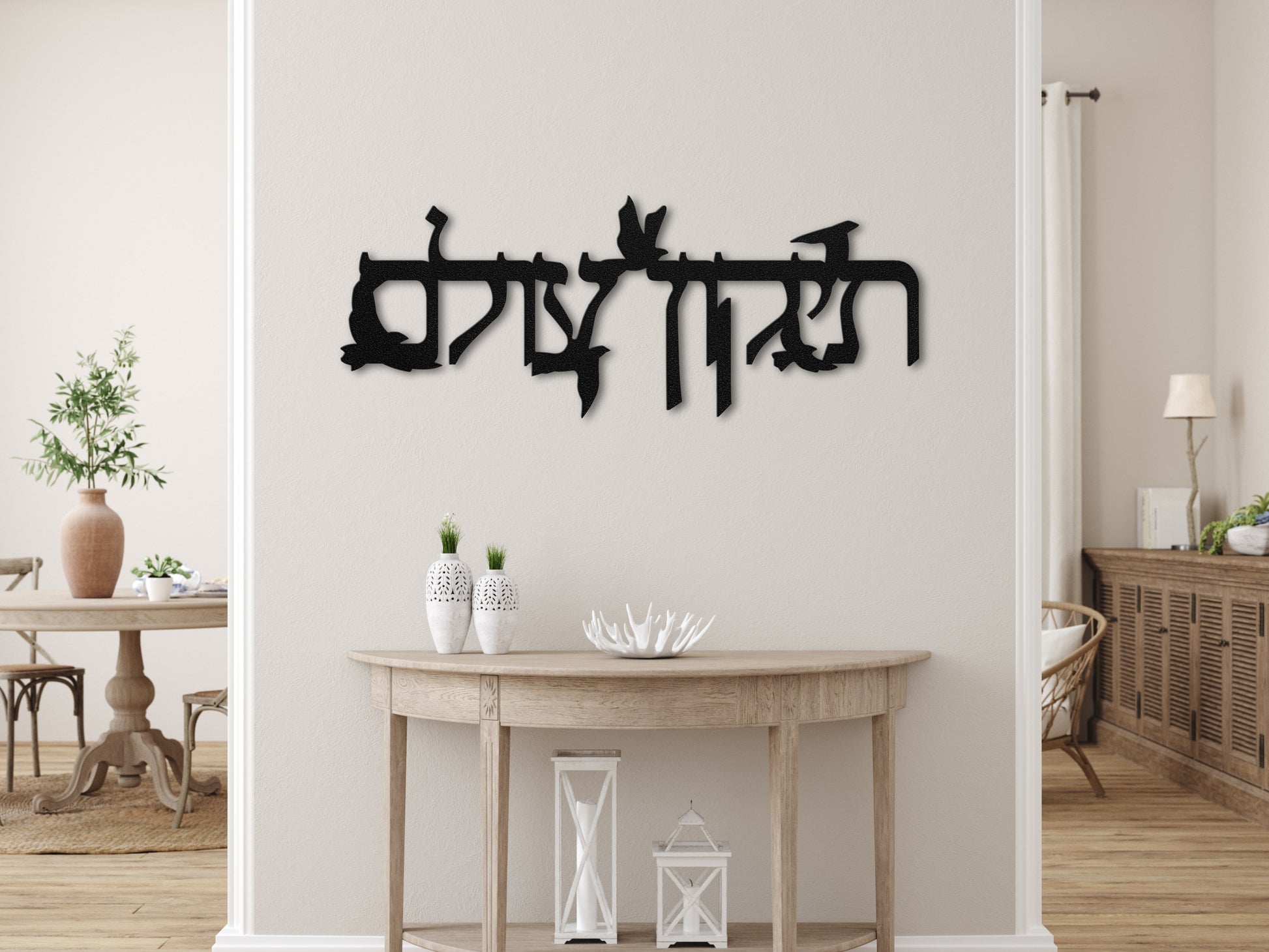 Metal sign "תיקון עולם" with flying doves displayed above a wooden console in a cozy room, featuring warm wood tones and minimalistic decor.